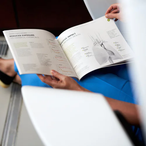 A person sitting on a chair, reading a scientific magazine.