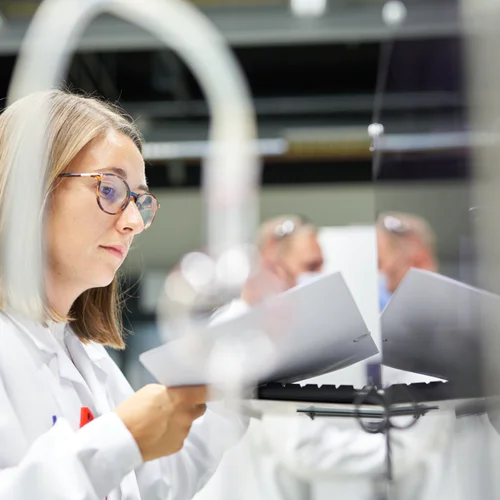 A scientist in a lab looking at a document.