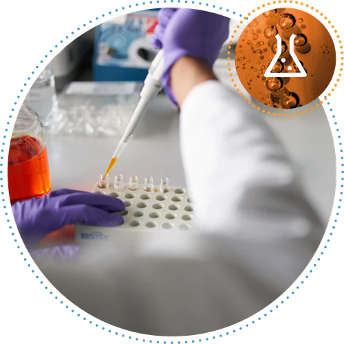 Scientist in a white coat holds a transparent tube, examining its content.