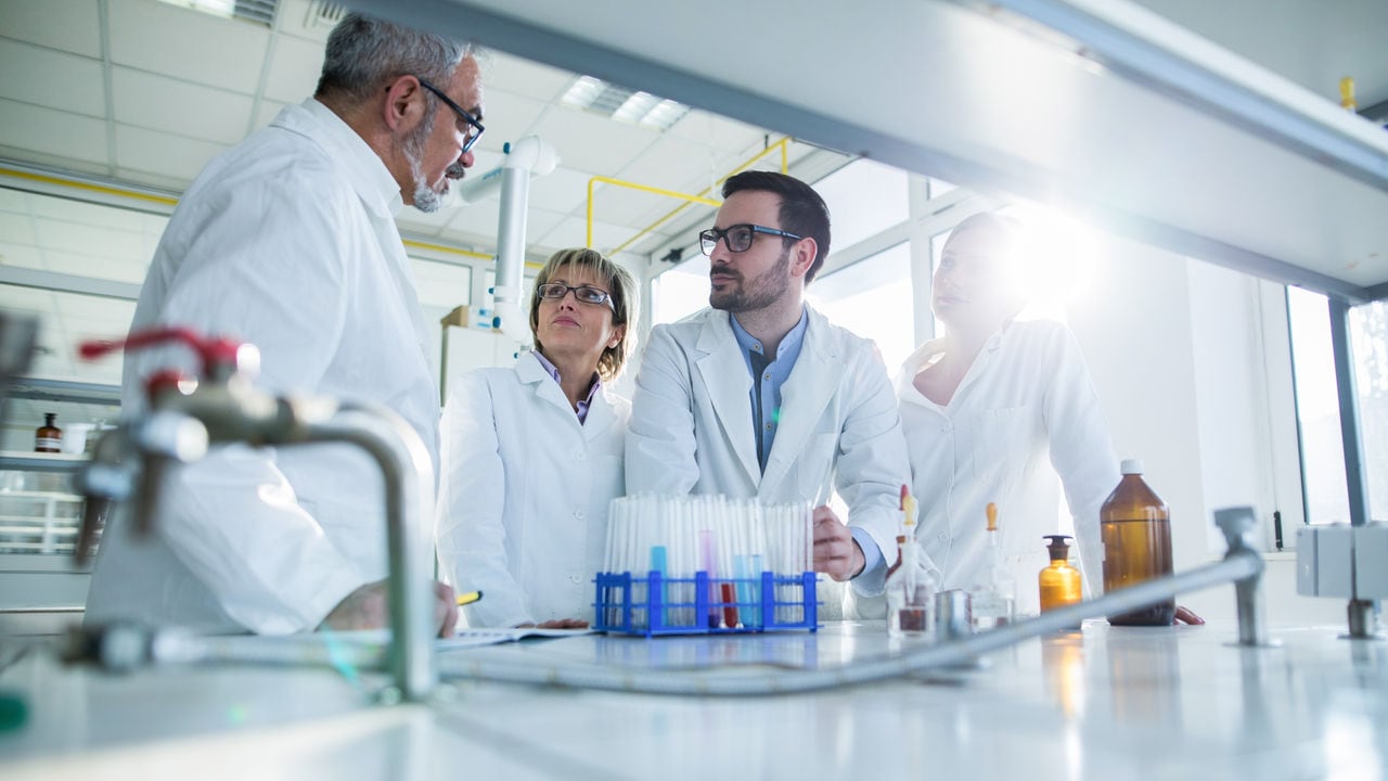 Low angle view of group of biochemists talking about new discovery in laboratory.