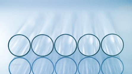Multiple test tubes aligned in a row horizontally with a blue background.