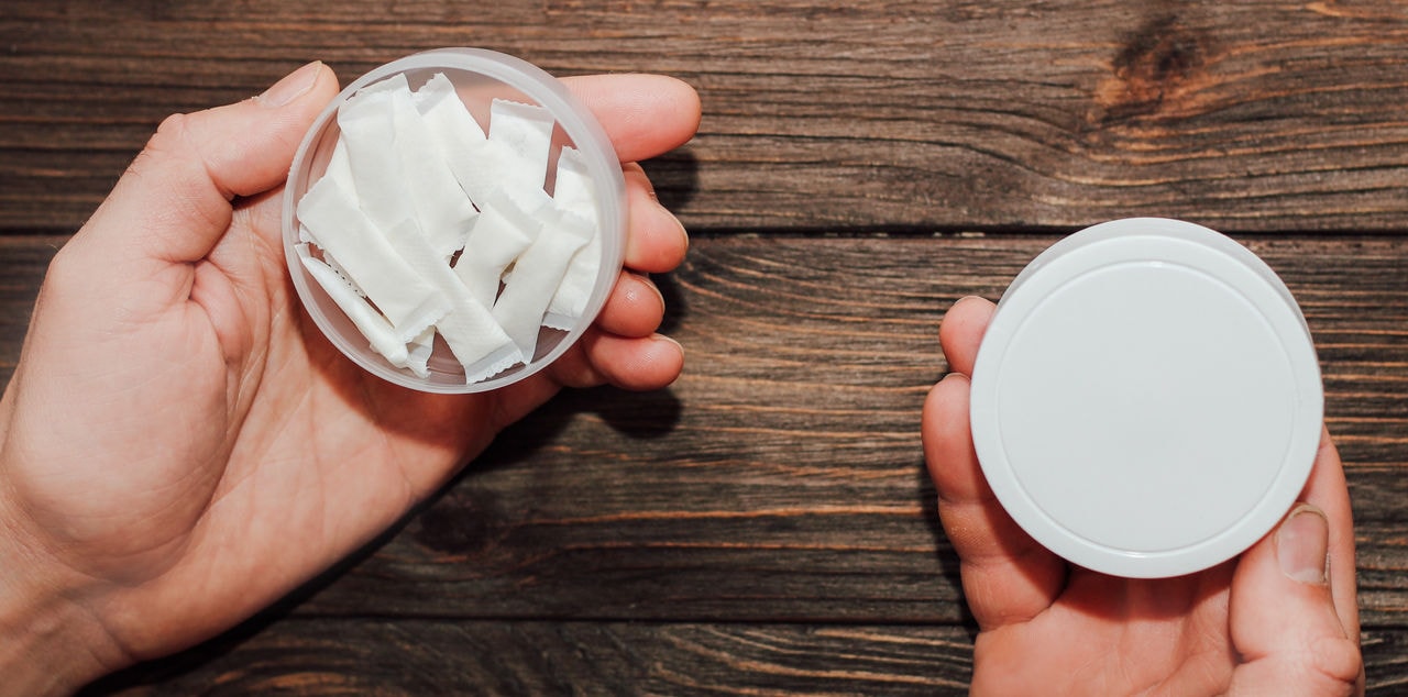 Male hands hold in hand a box of snus