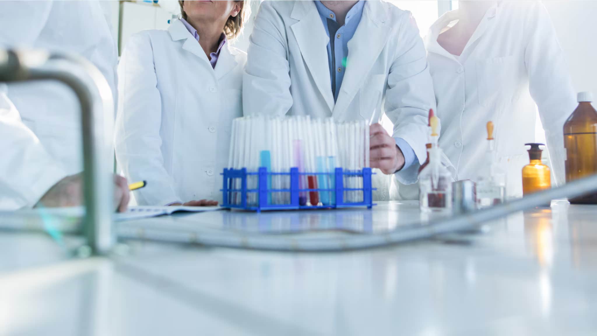Laboratory scene featuring scientists using equipment and pipettes for harm reduction research.