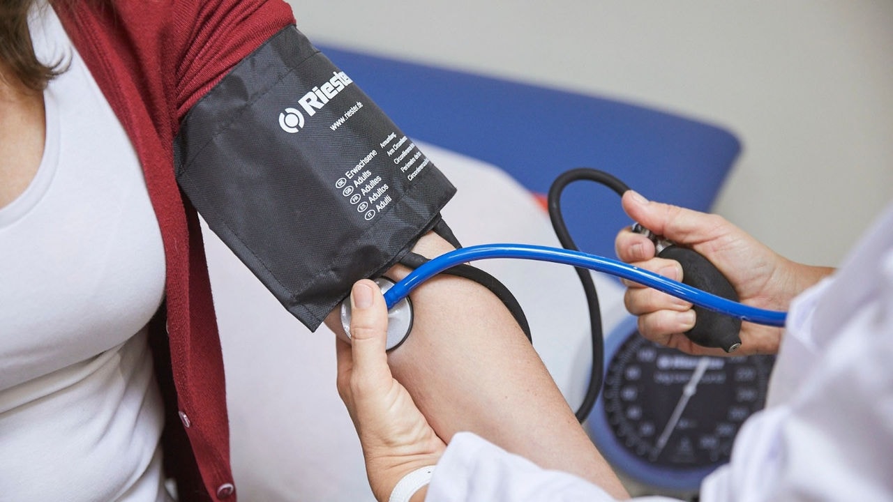 Medical worker measures blood pressure to a patient.