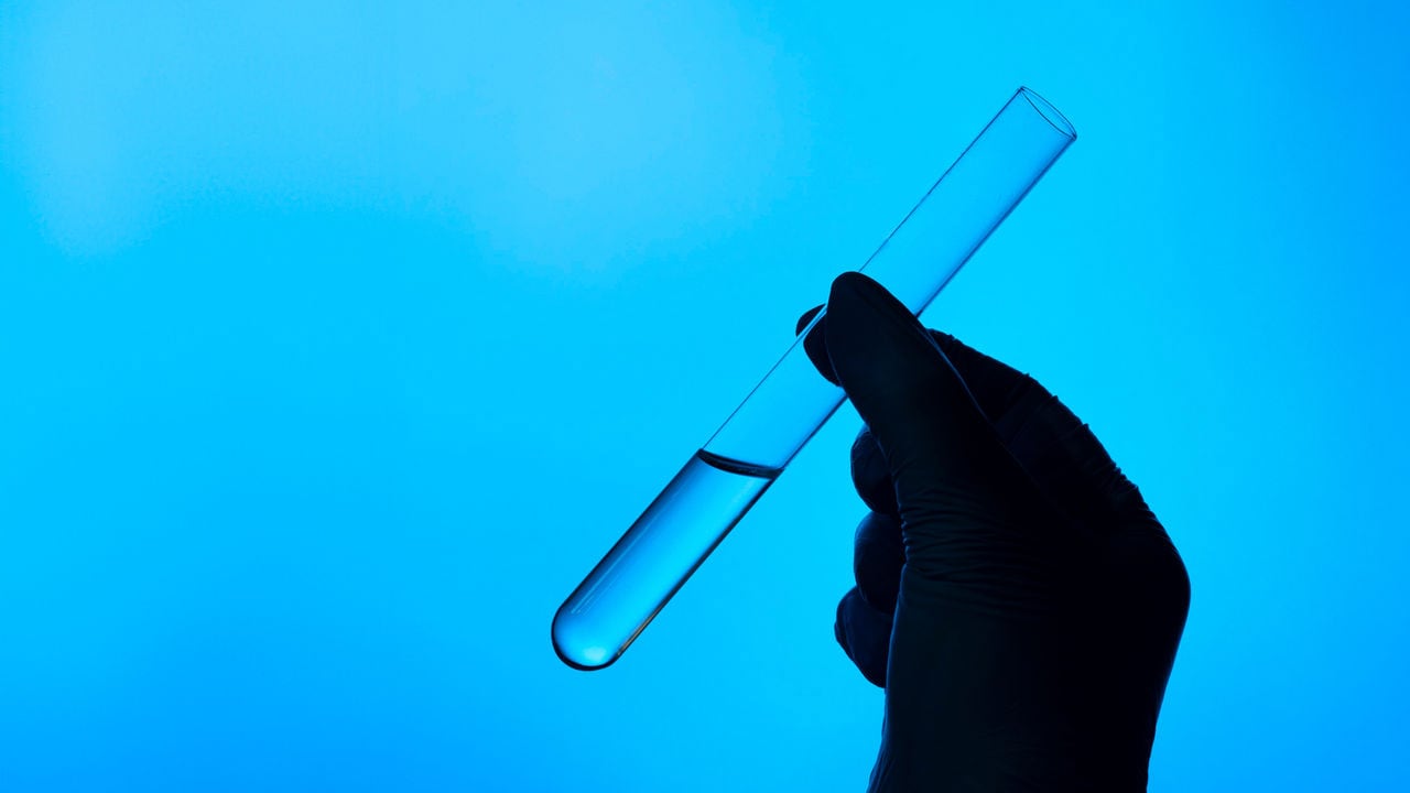 Gloved hand holding test tube