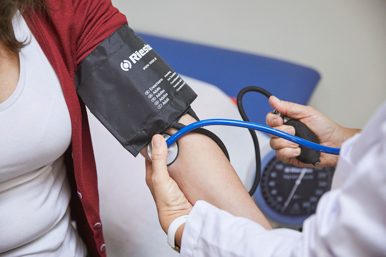 A medical worker measures a patient's blood pressure using a  sphygmomanometer.