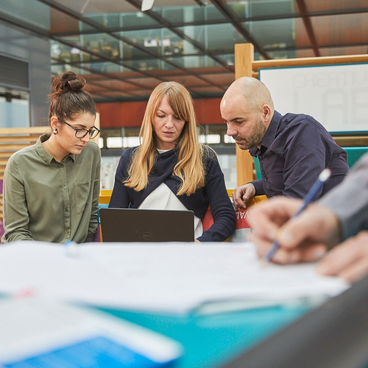 Three people looking at computer
