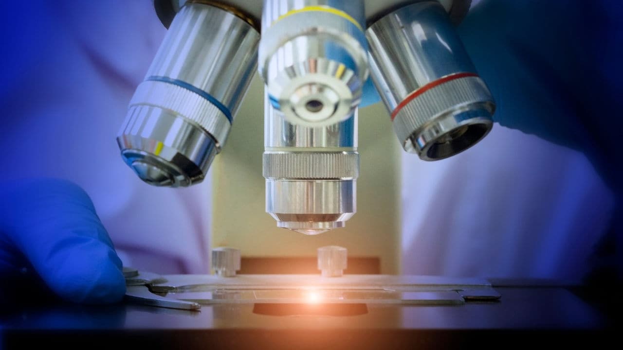 Close-up shot of microscope with metal lens at microbiological laboratory.