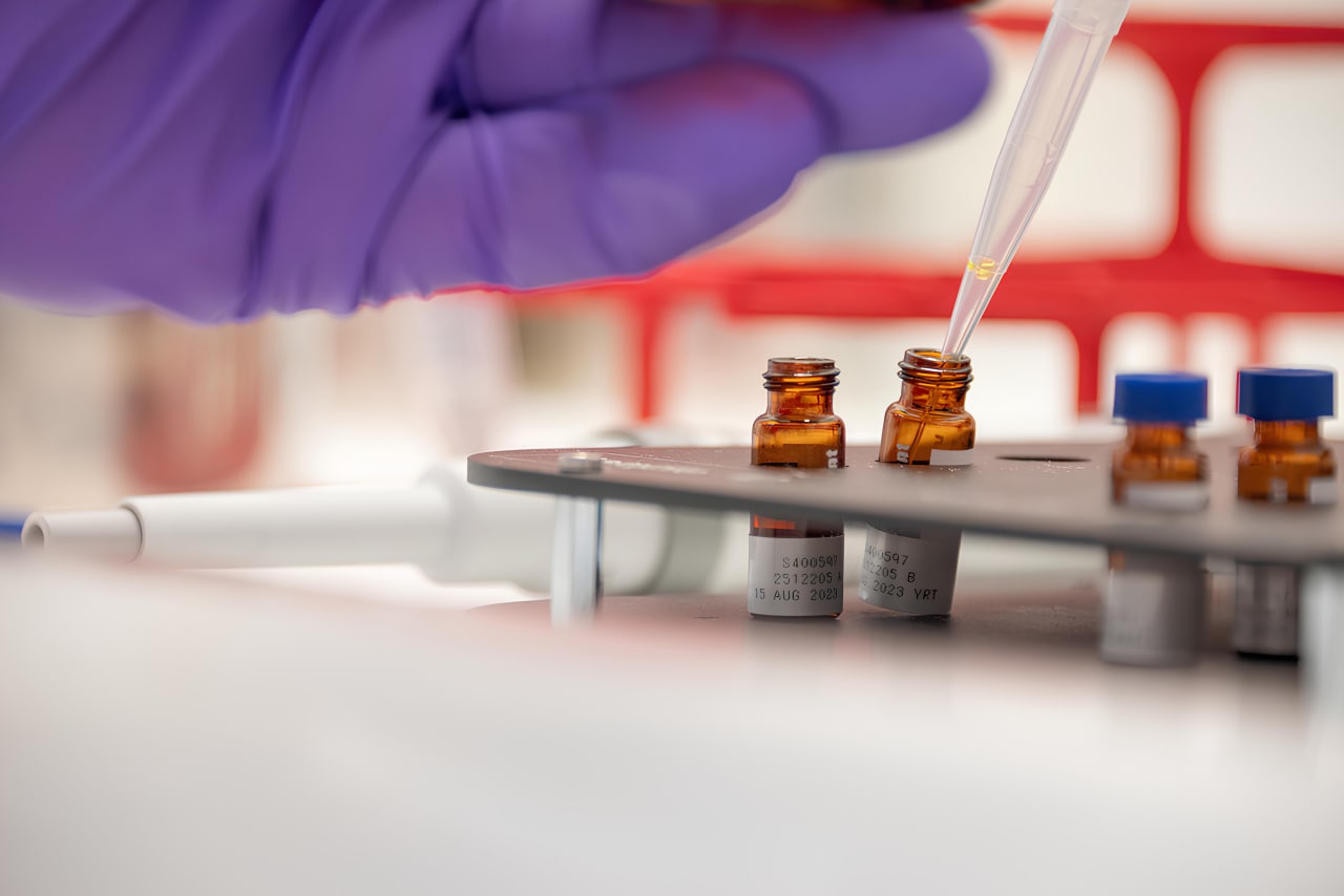 Scientists pipetting in vials in the Cube laboratory